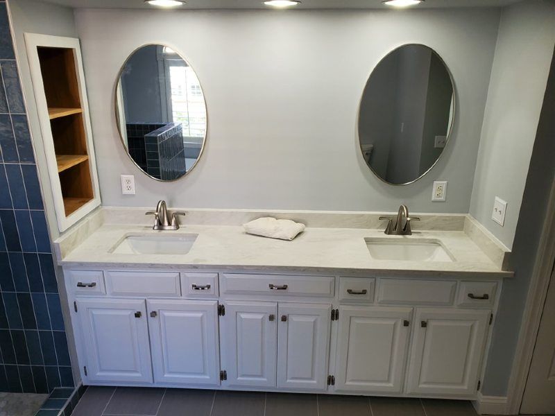 A bathroom with two sinks and two mirrors.
