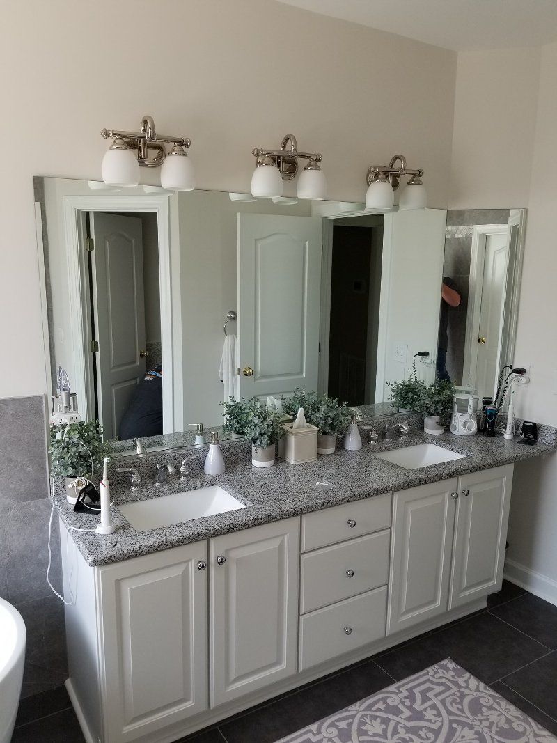 A bathroom with two sinks and a large mirror.