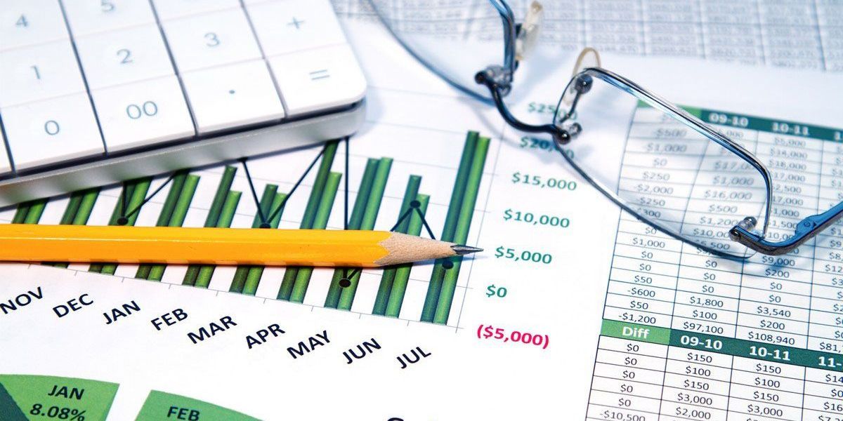 Financial documents with a calculator, pencil, and glasses. Green bar graph showing progress.