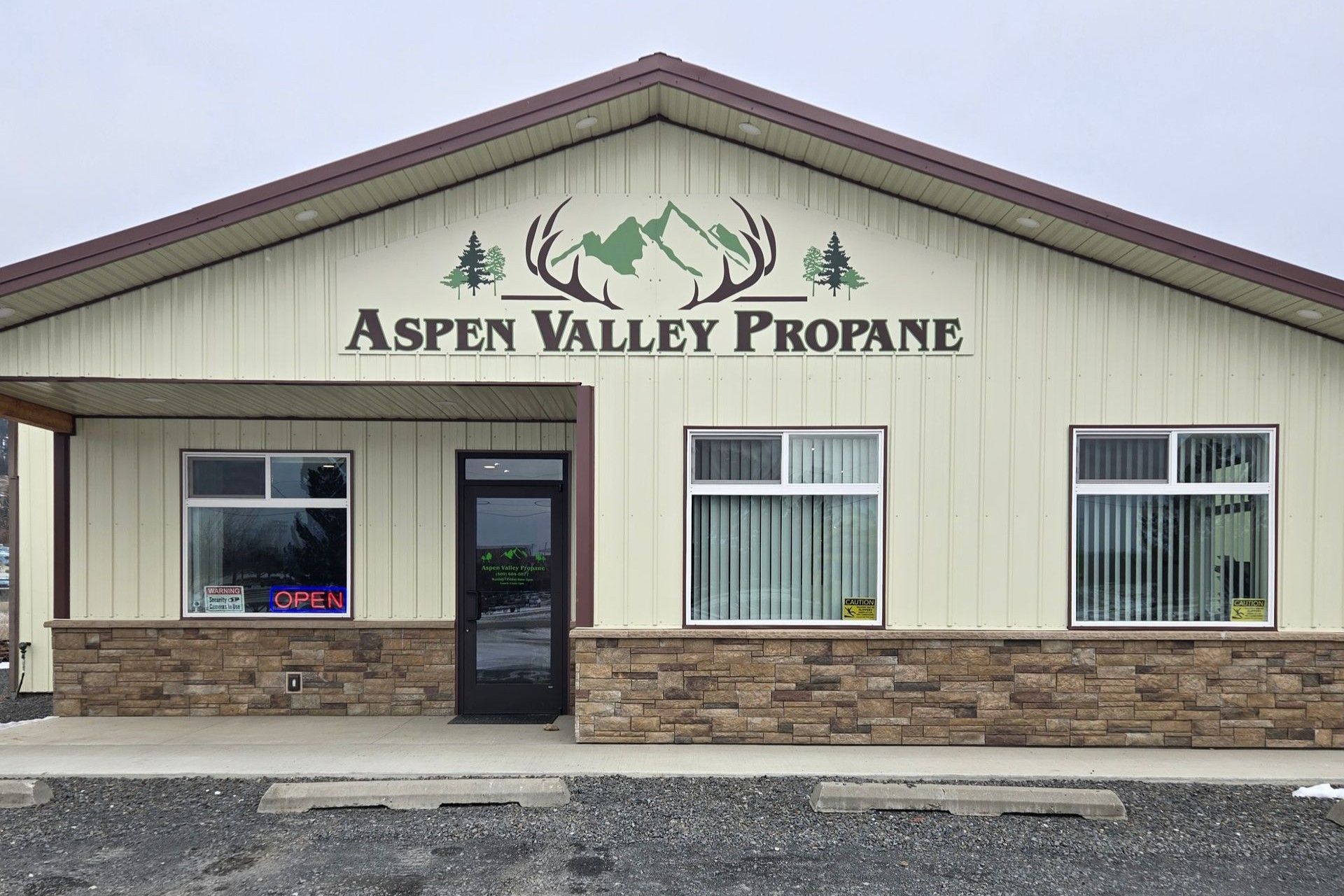 Aspen Valley Propane building with stone facade, tan siding, and logo featuring mountains and antlers.