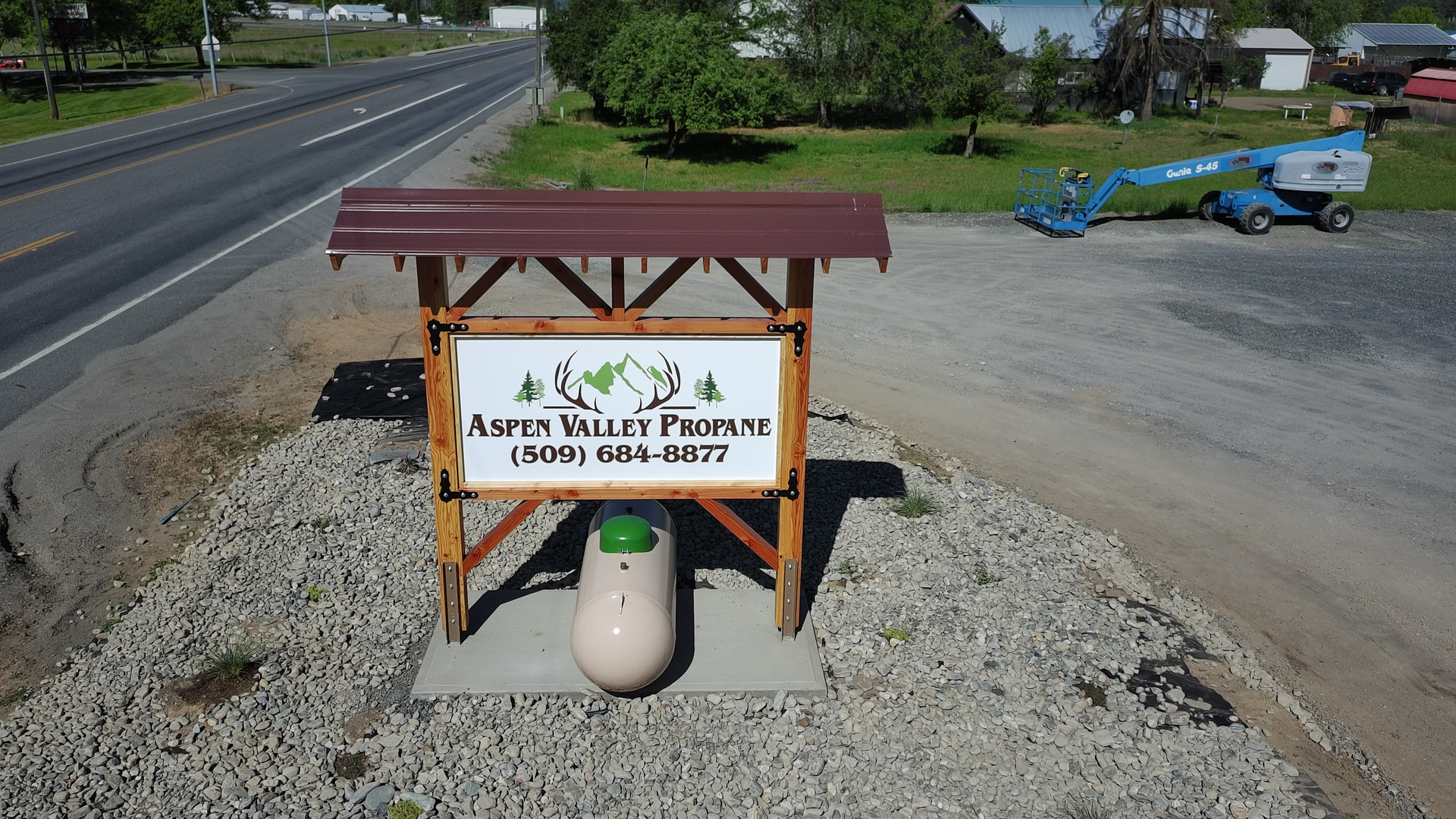 Sign for Aspen Valley Produce, brown wooden frame, white sign, roadside.