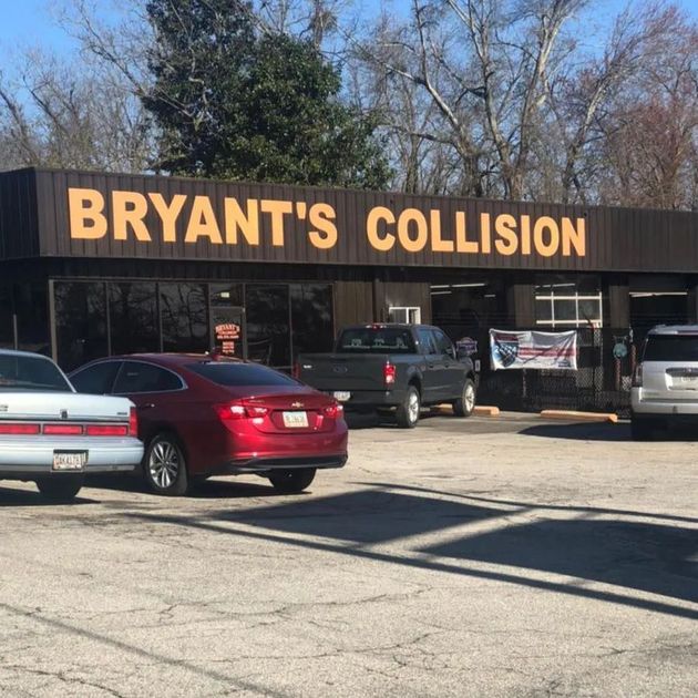Bryant's Collision storefront with parked cars in front on a sunny day