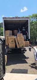 A moving truck filled with boxes is parked in a driveway.