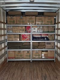 The inside of a moving truck filled with boxes and shelves.