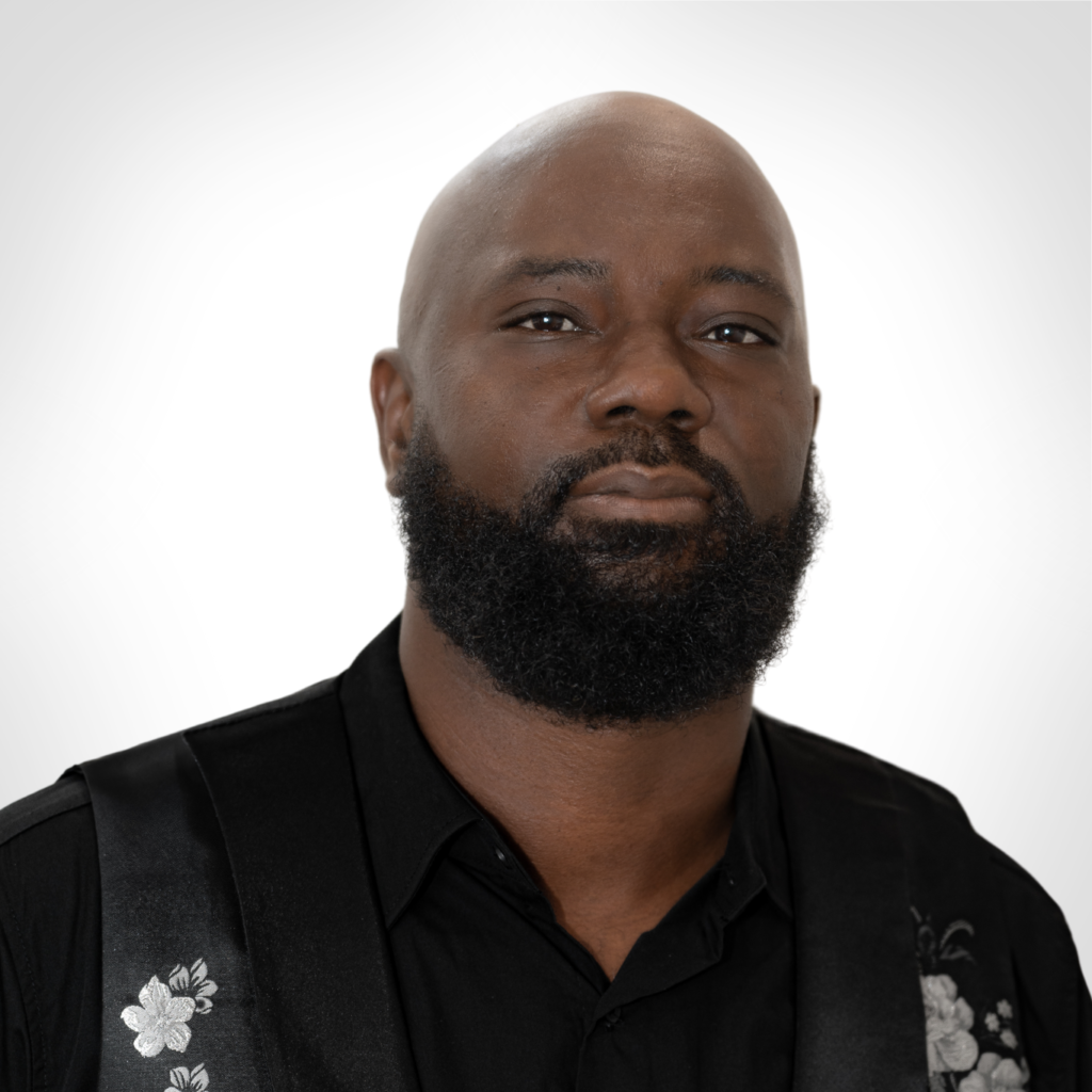 Studio portrait of a bearded man in a black shirt against a white background