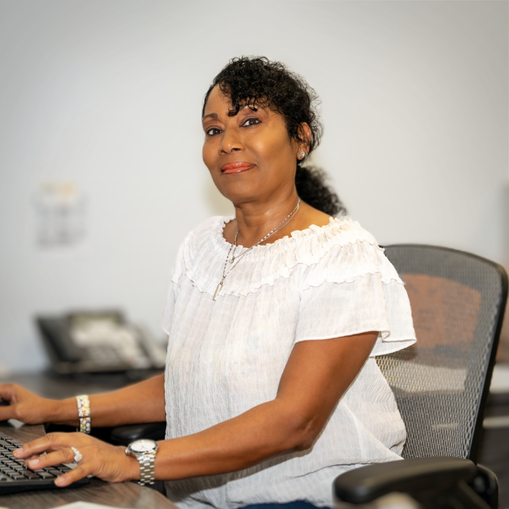 Woman seated at a desk using a computer in an office setting