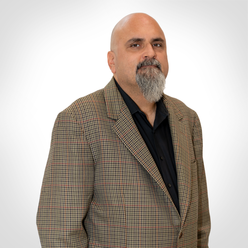 Bald man with a goatee wearing a brown plaid blazer and black shirt on a white background