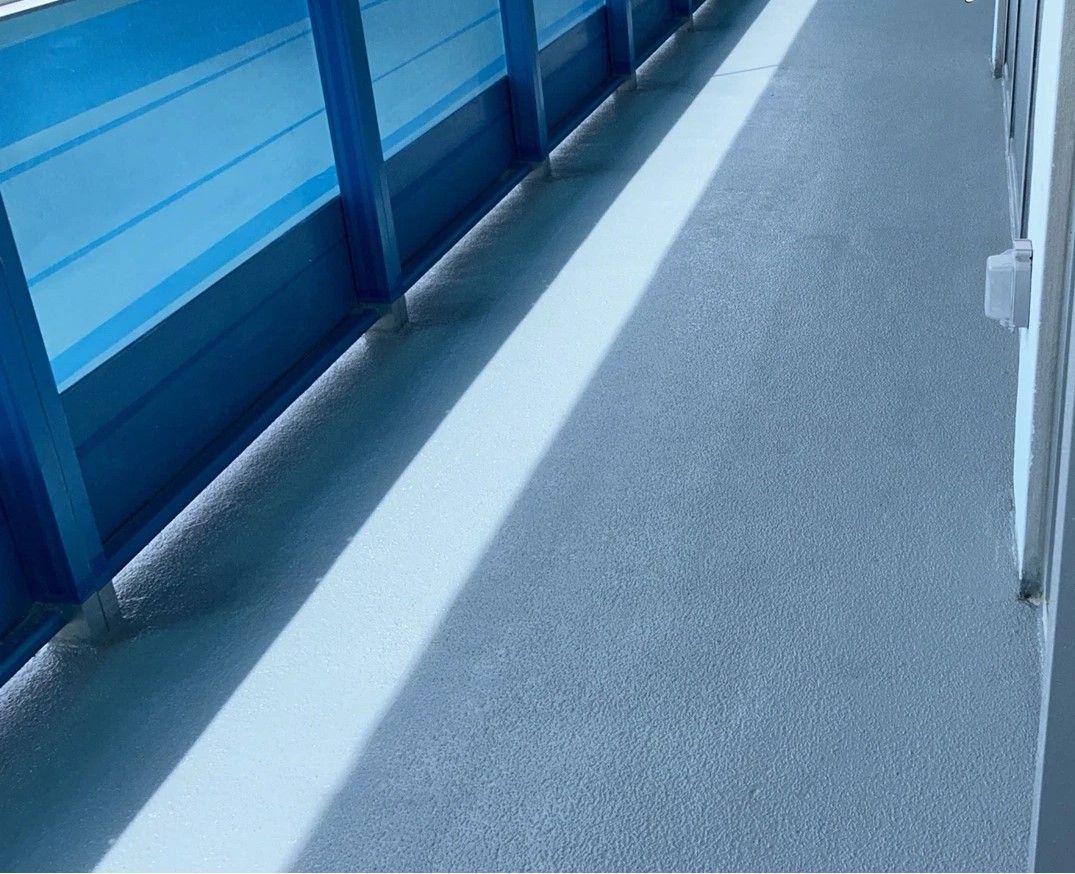 Blue-sided walkway with a white line and gray pavement in bright sunlight