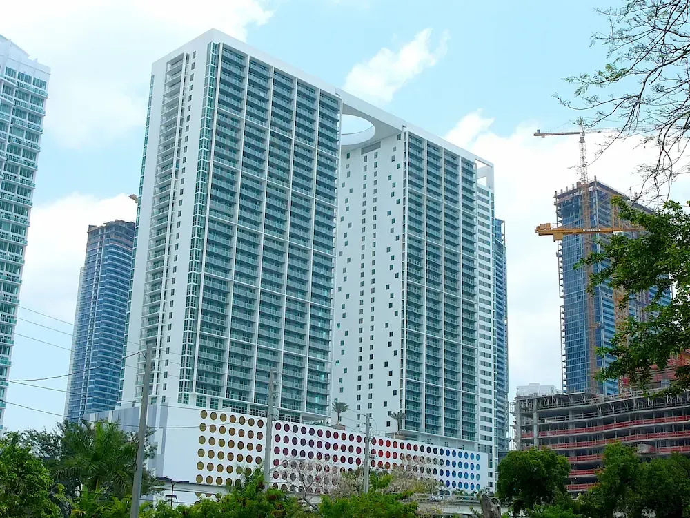 Modern high-rise apartment towers under construction against a blue sky