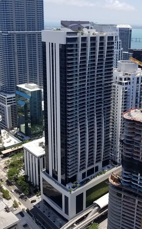 Tall modern high-rise office building in a city skyline, with glass and concrete facade.