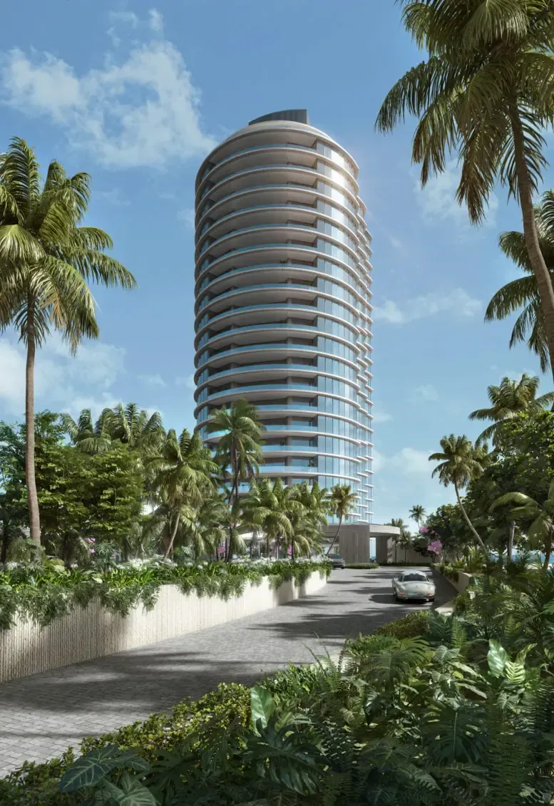 Tall modern cylindrical tower amid palm trees under a blue sky, viewed from a landscaped driveway.