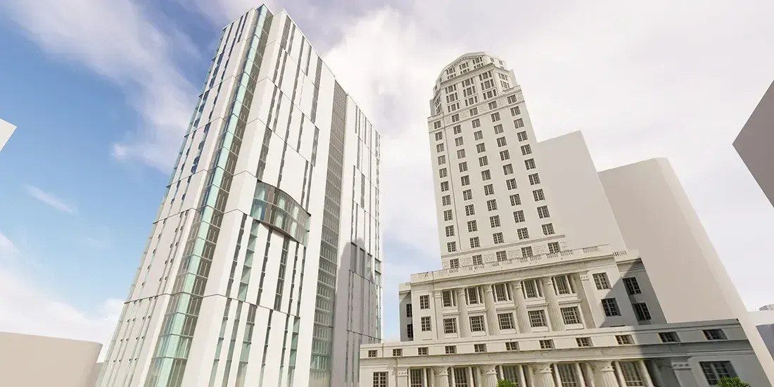 Tall modern buildings against a blue sky, one striped and one beige with arched windows