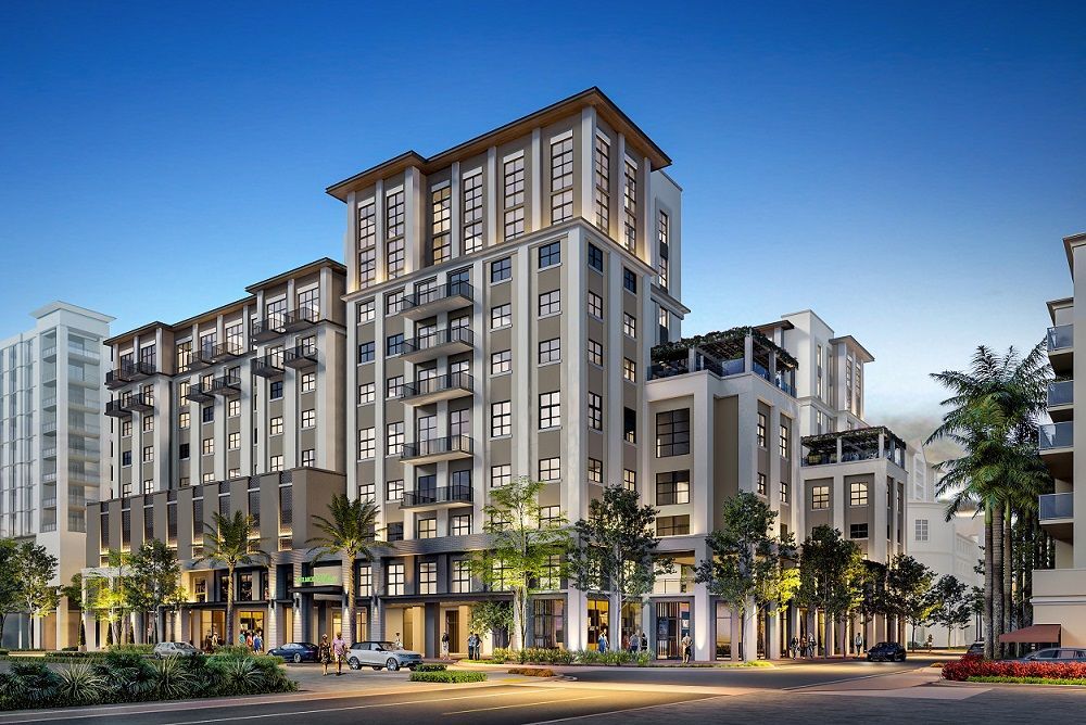 Modern multi-story apartment building with balconies and palm trees at dusk