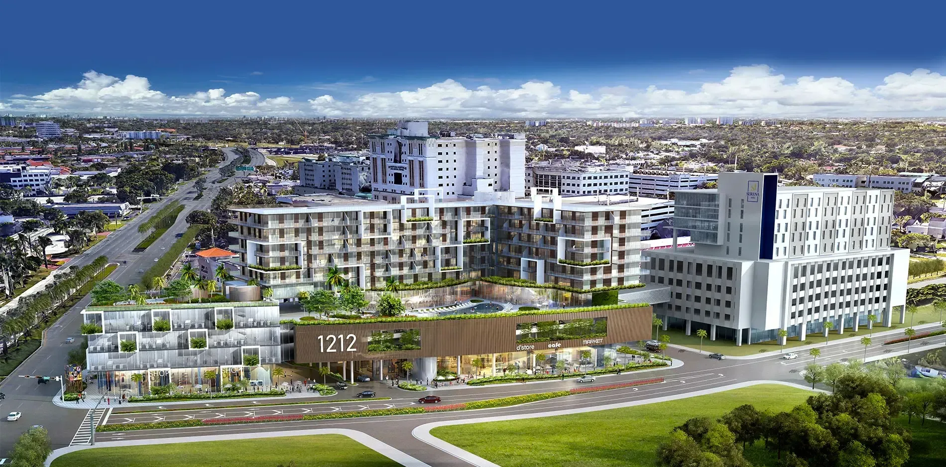 Aerial view of a modern apartment and office complex with landscaped grounds under a clear blue sky