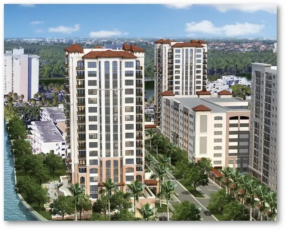 High-rise apartment towers in a landscaped residential complex under a blue sky.