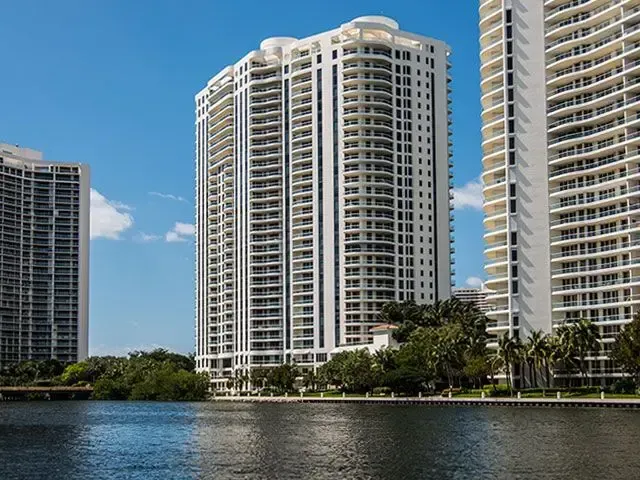 High-rise condo towers along a waterfront under a blue sky