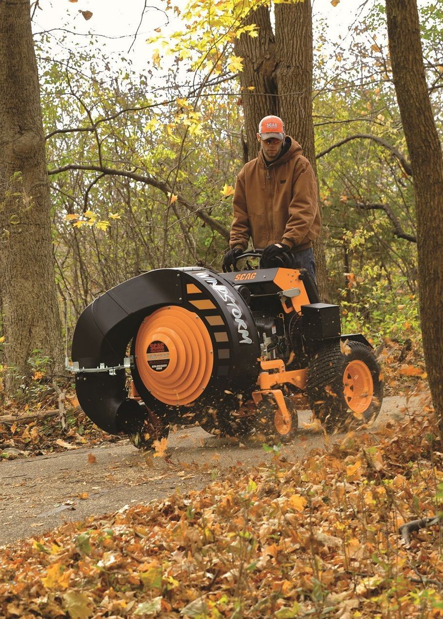 A man is driving a lawn mower through the woods