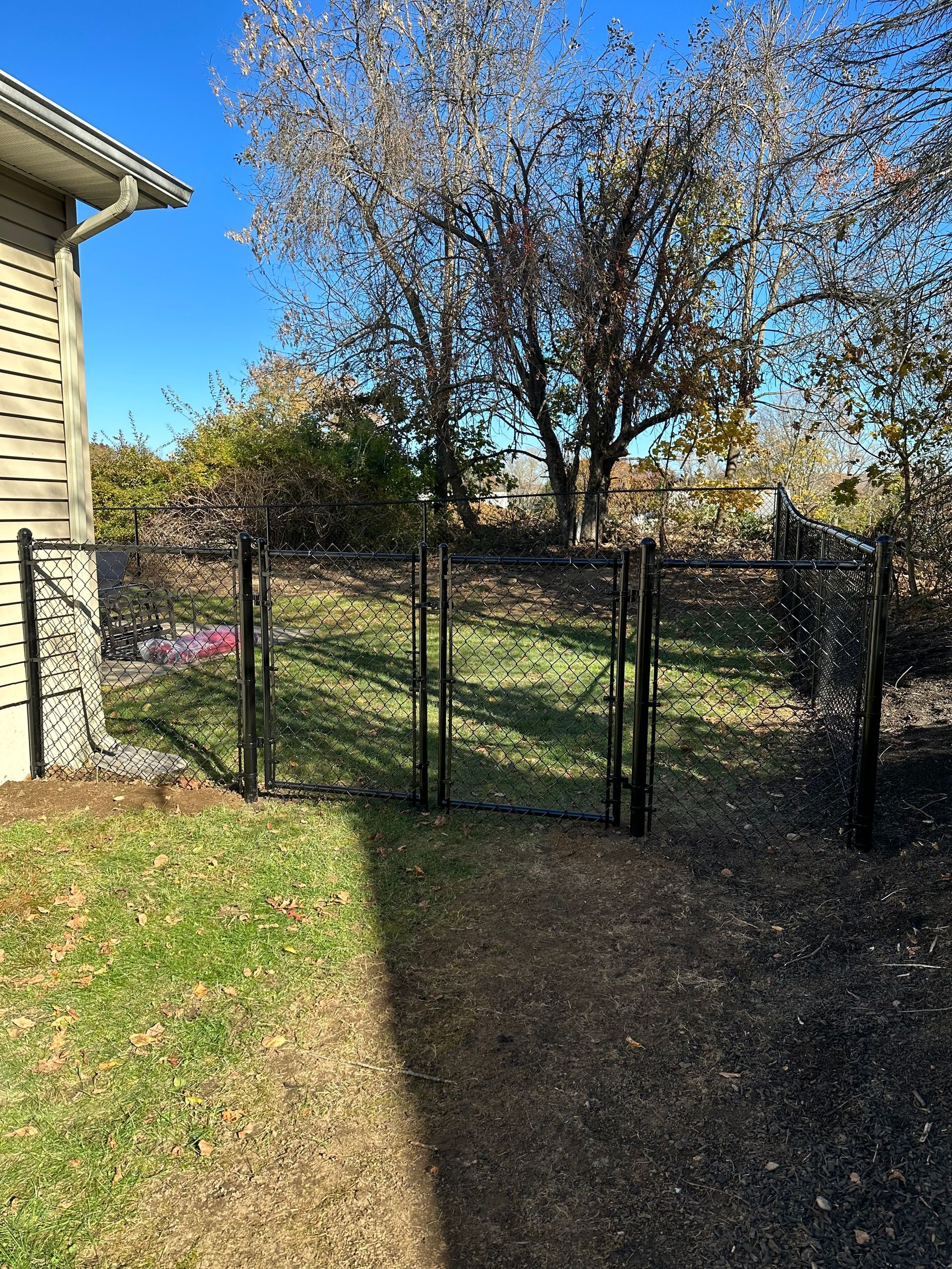 There is a fence in the backyard of a house.