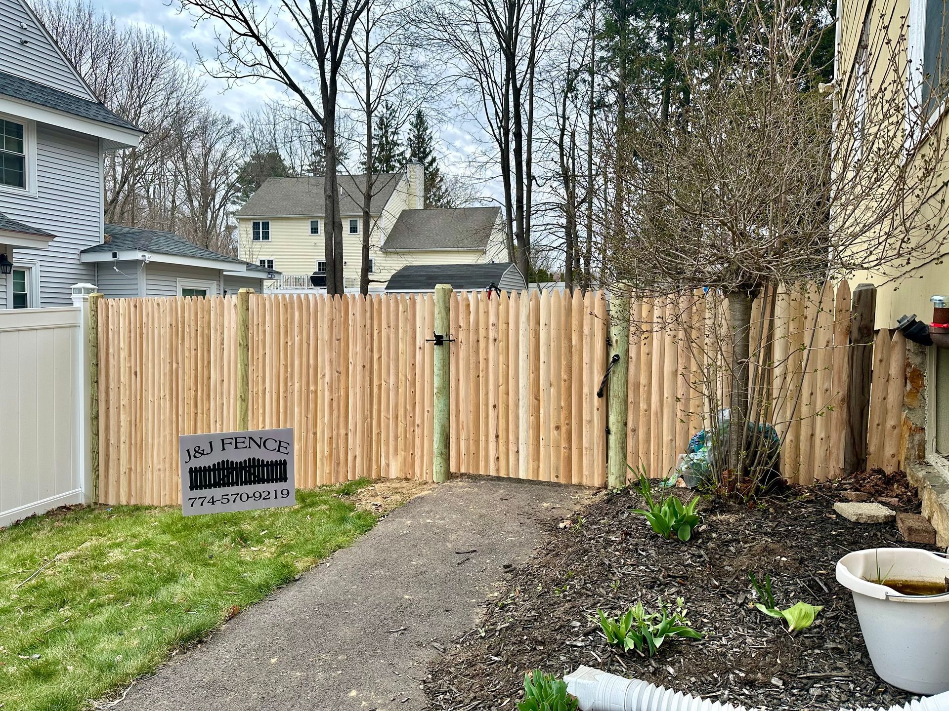 A wooden fence with a gate in the backyard of a house.