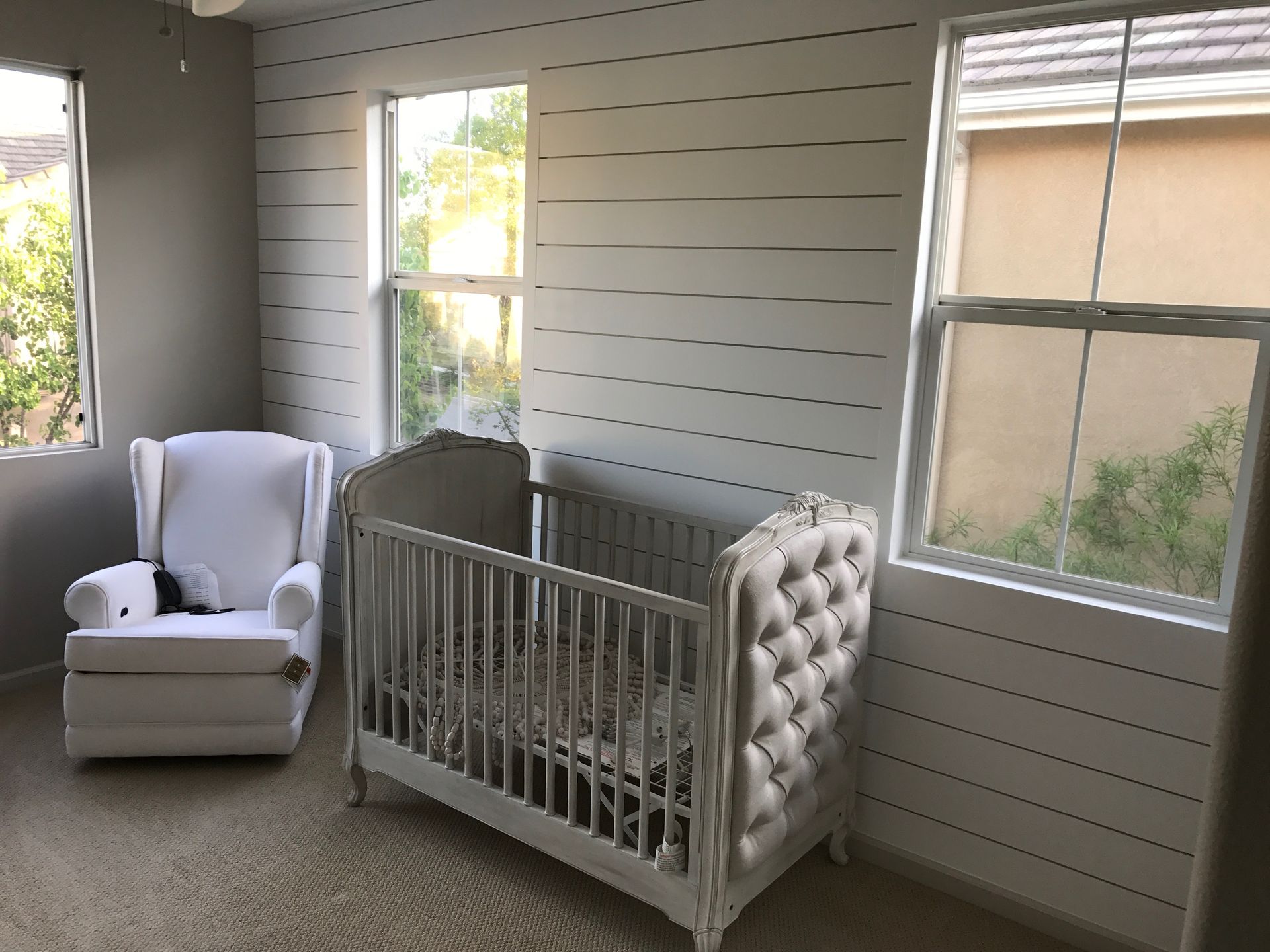 A nursery with a crib , chair and window