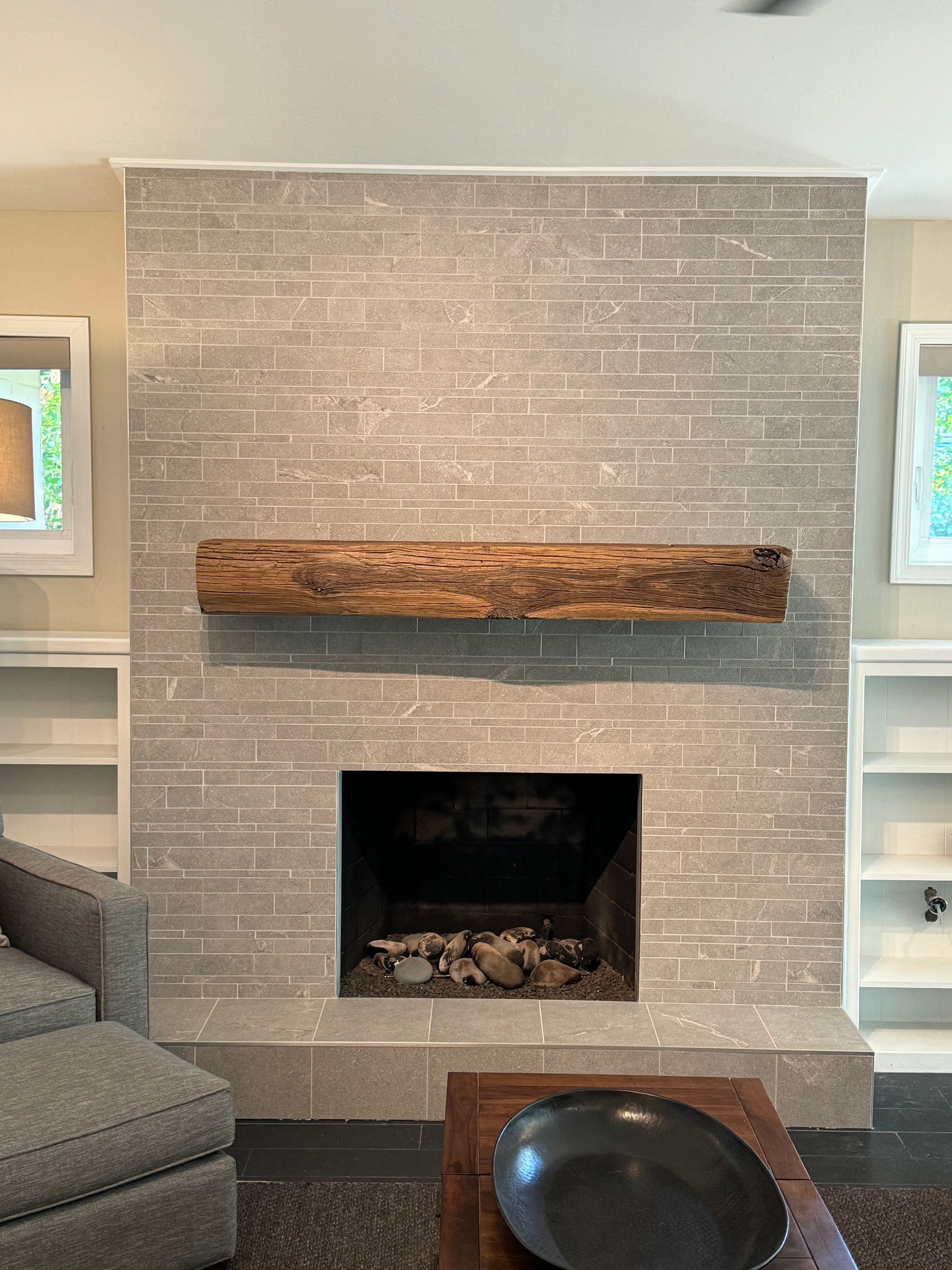 A living room with a fireplace and a wooden mantle