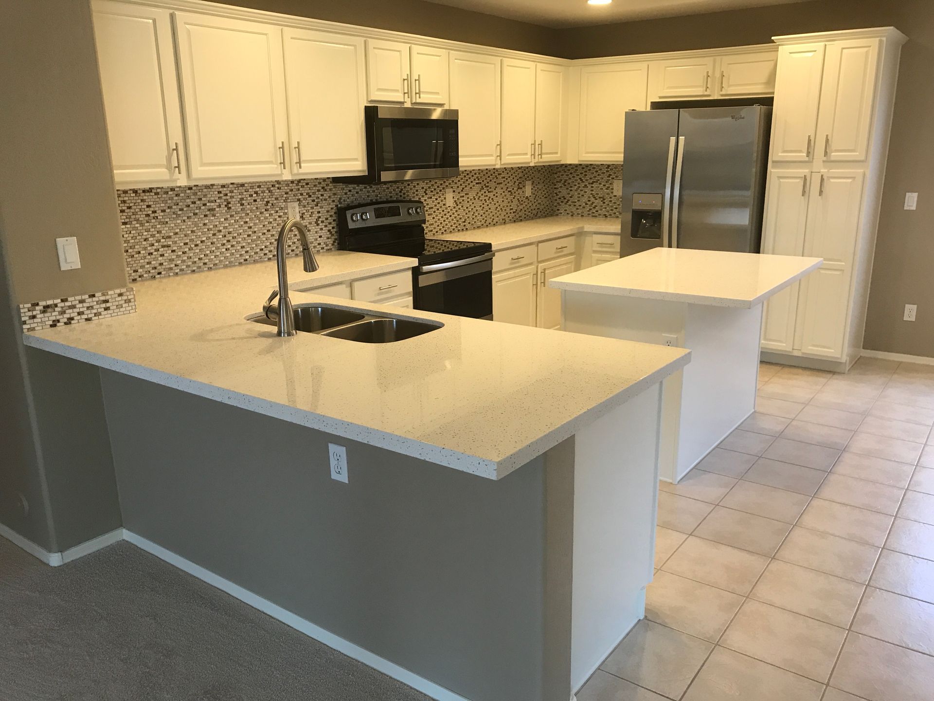 A kitchen with white cabinets and stainless steel appliances