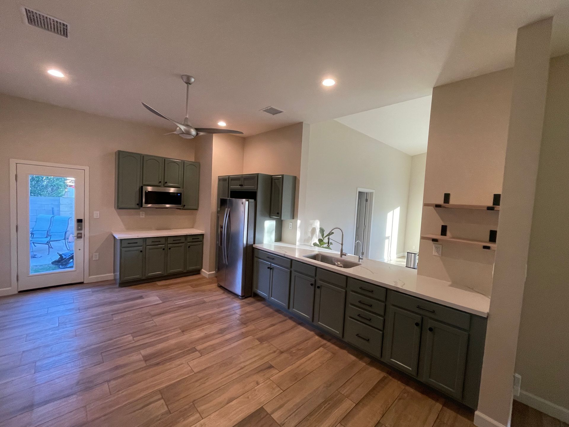 A kitchen with a sink , refrigerator , microwave and stainless steel appliances.