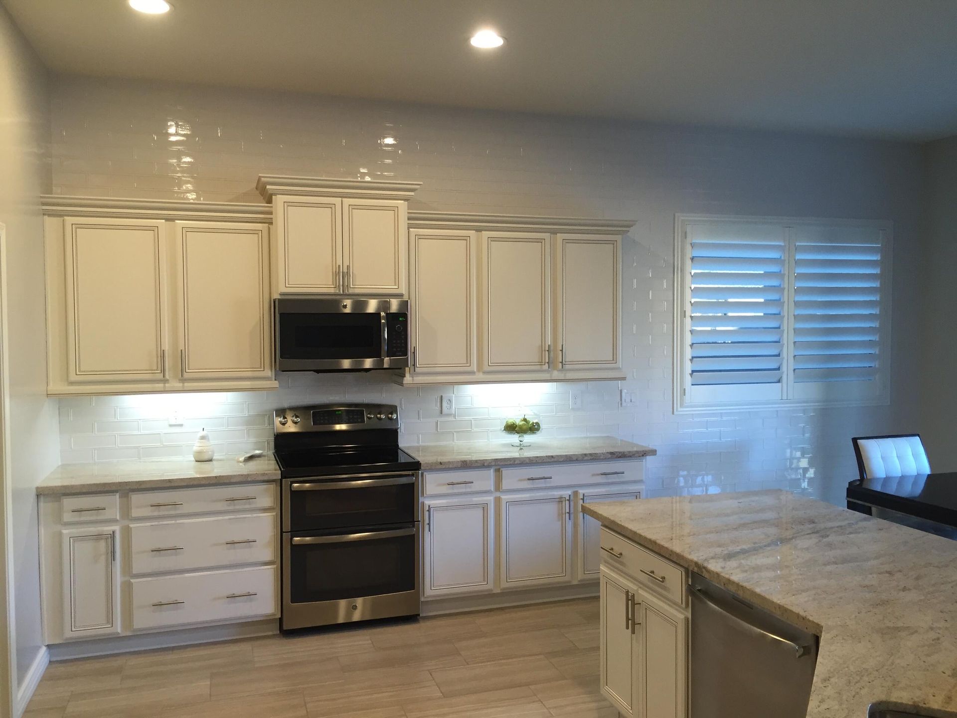 A kitchen with white cabinets and stainless steel appliances
