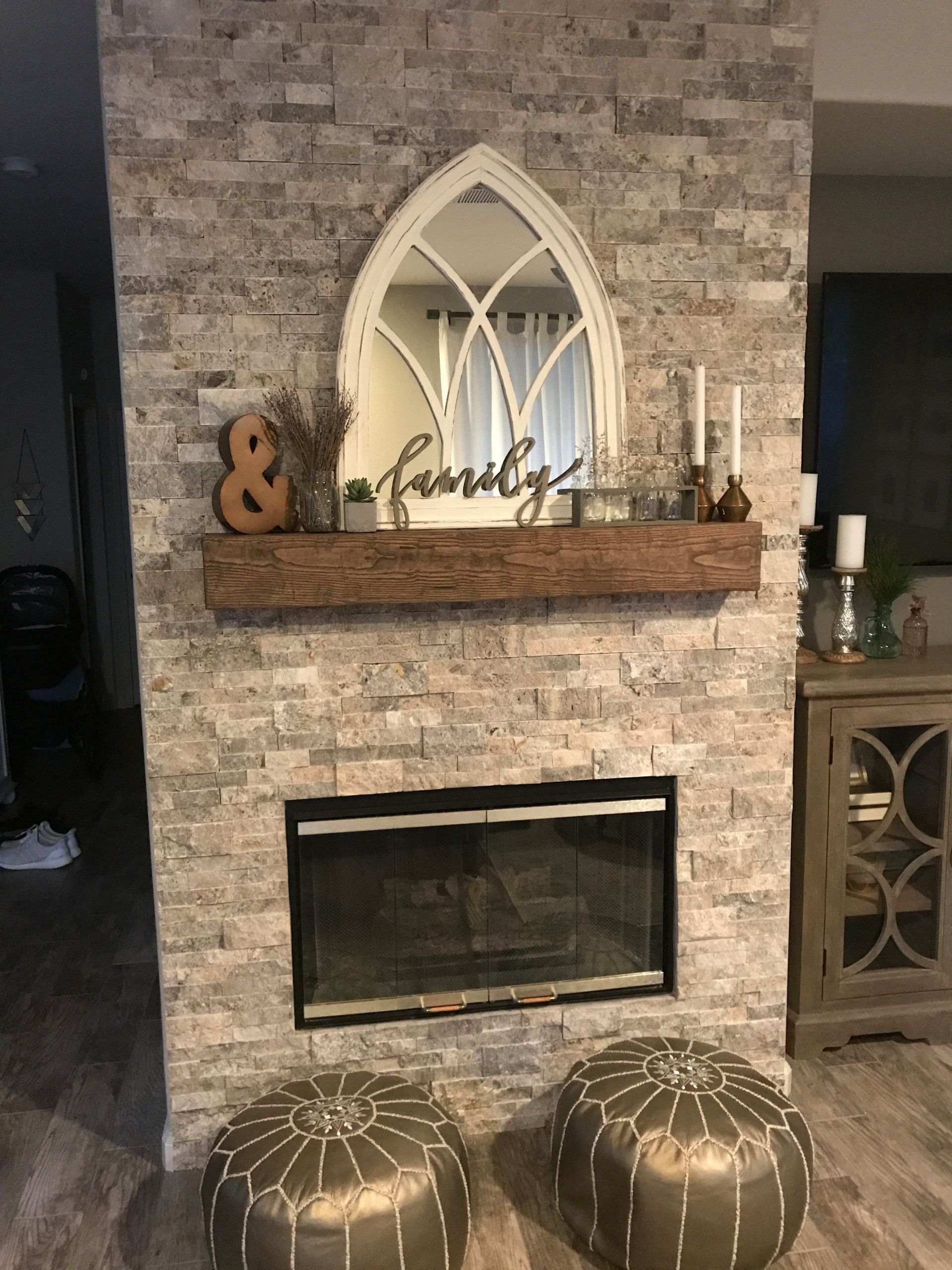 A living room with a fireplace and a mirror above it.