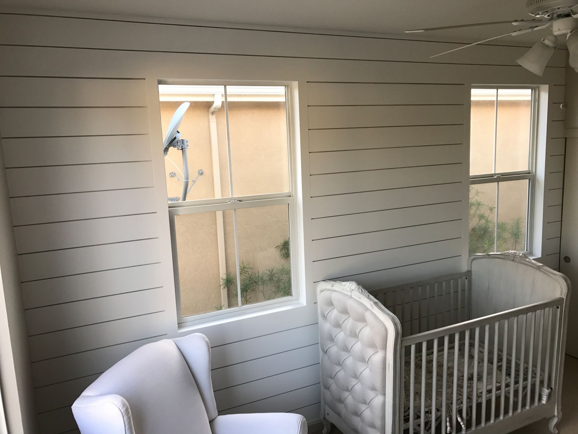 A room with a crib and a chair in it
