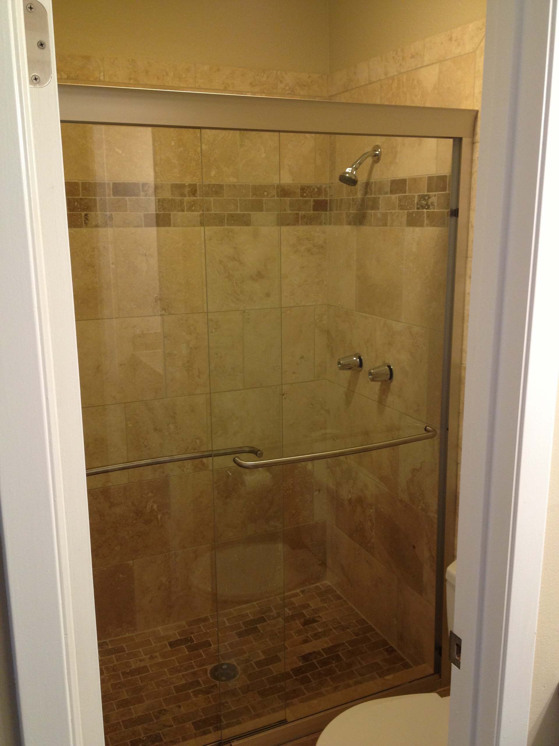 A bathroom with a walk in shower and a toilet