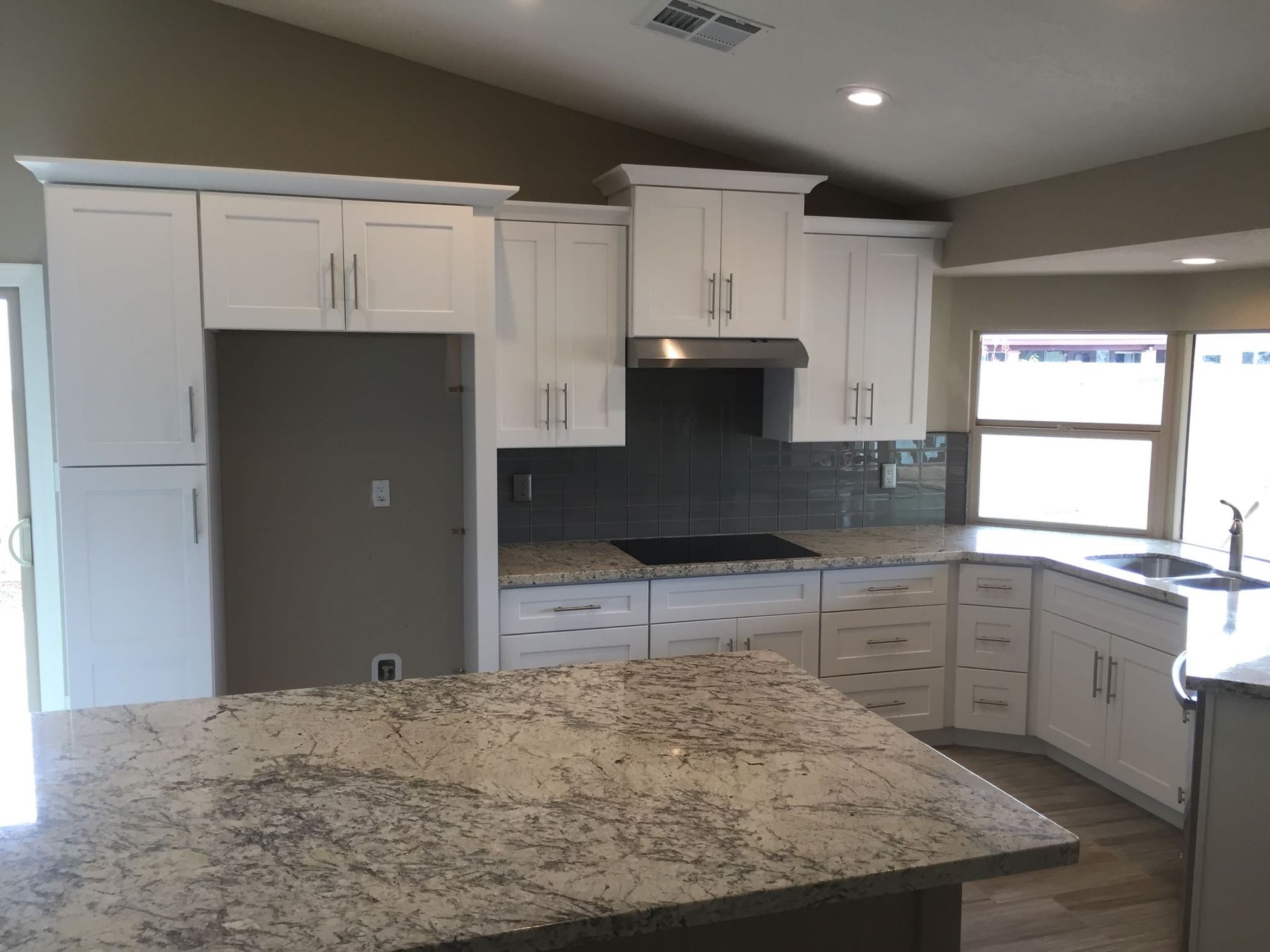 A kitchen with white cabinets and granite counter tops