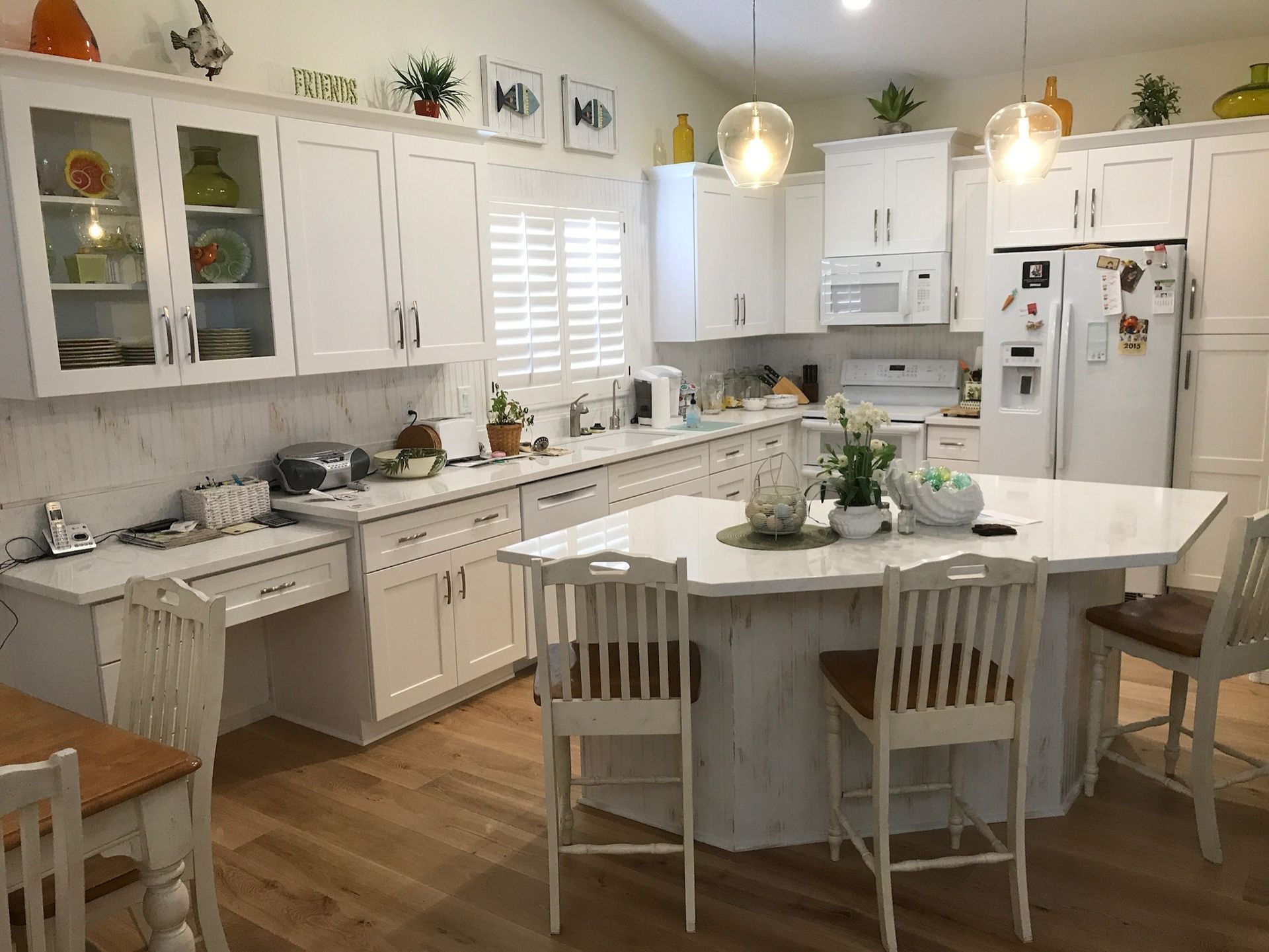 A kitchen with white cabinets and a large island.