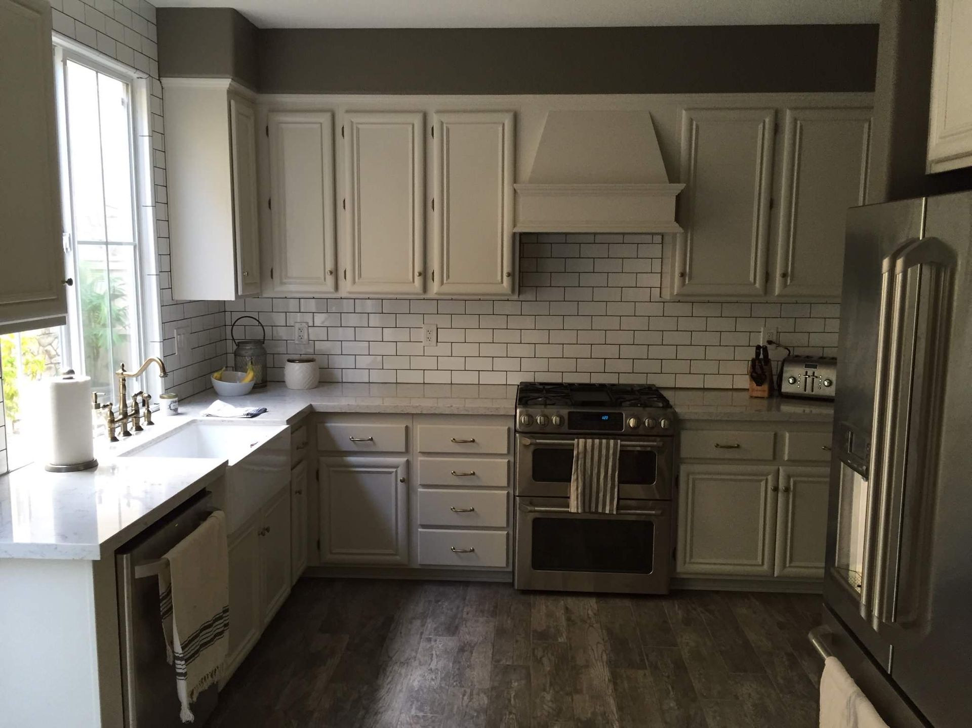 A kitchen with white cabinets and stainless steel appliances
