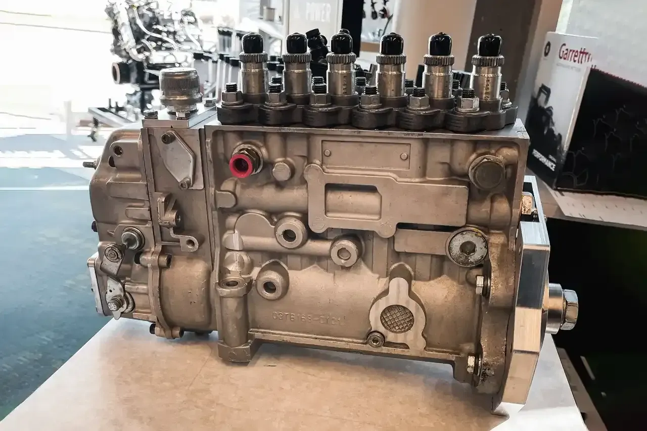 Silver diesel fuel injection pump with six upper nozzles.