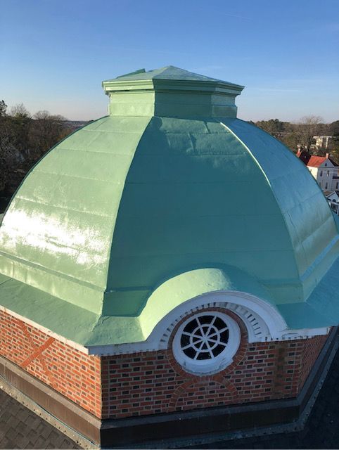 A green dome on top of a brick building