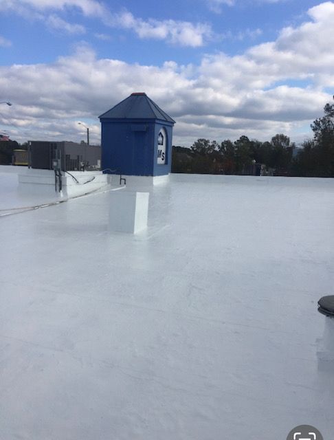 A white silicone coated roof with a blue chimney on top of it