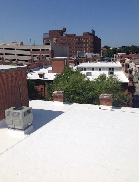 A white roof with a brick building in the background