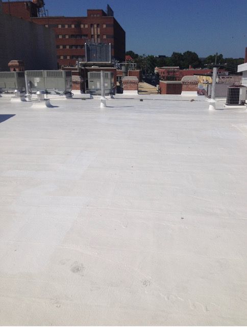 A white roof with a brick building in the background