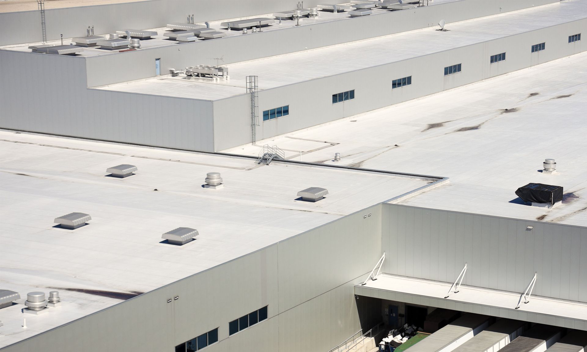An aerial view of a large building with a white roof