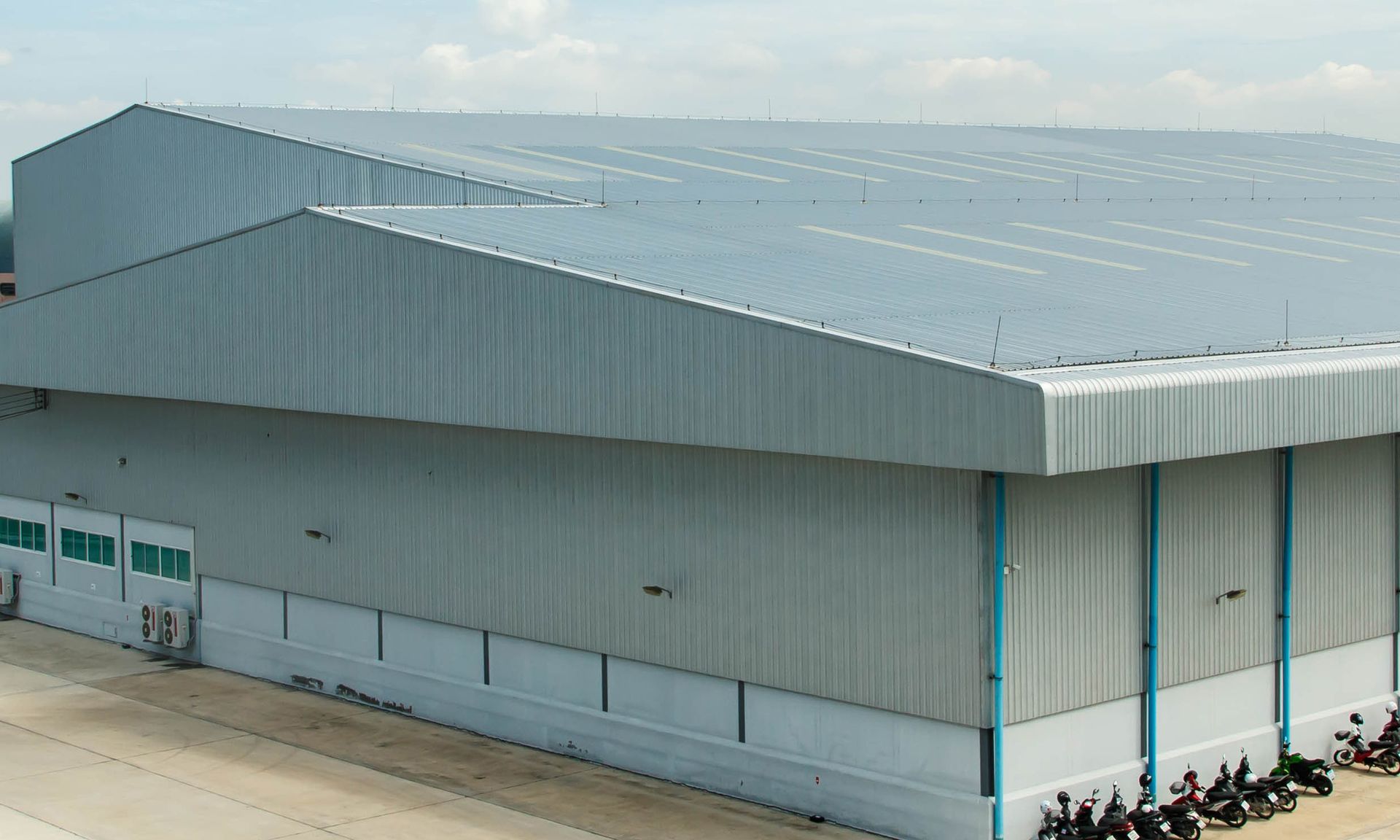 A large warehouse with motorcycles parked in front of it