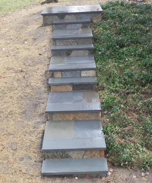 Stone steps leading up a grassy hillside.
