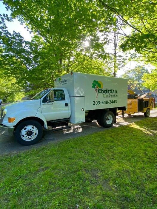 A white truck is parked on the side of the road next to a trailer