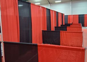 Red and black fabric partitions forming a maze-like indoor event space