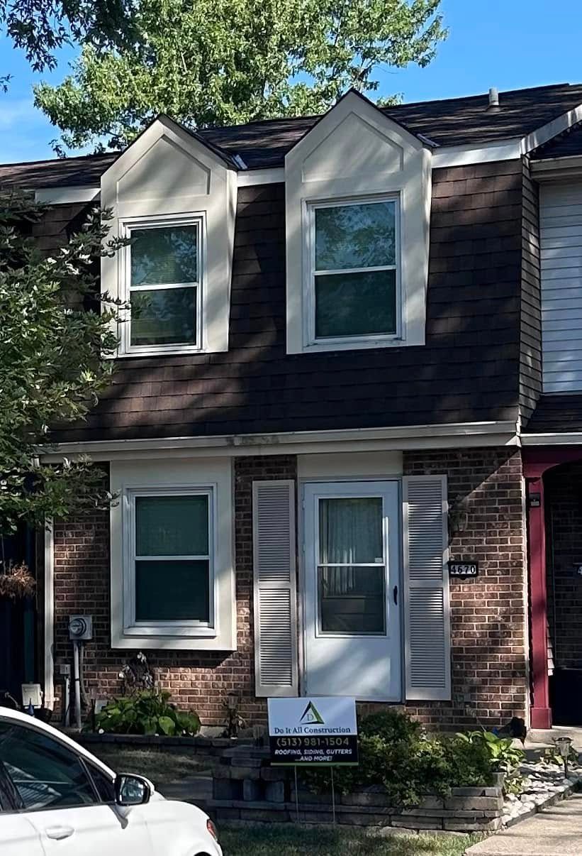 A brick house with a car parked in front of it.