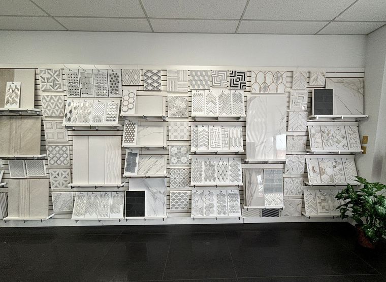 Wall of shelves filled with white papers and magazines in a bright room, with a plant at the right edge