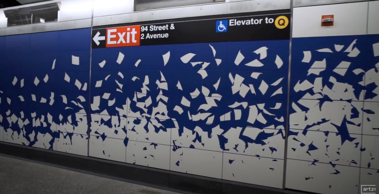 Subway platform wall with blue panels and scattered white paper-like fragments, near Exit and elevator signs