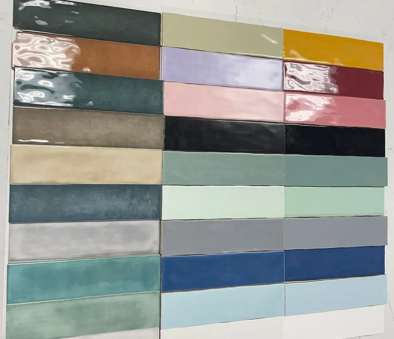Paint sample chart with rows of glossy color swatches in muted blues, greens, pinks, and neutrals