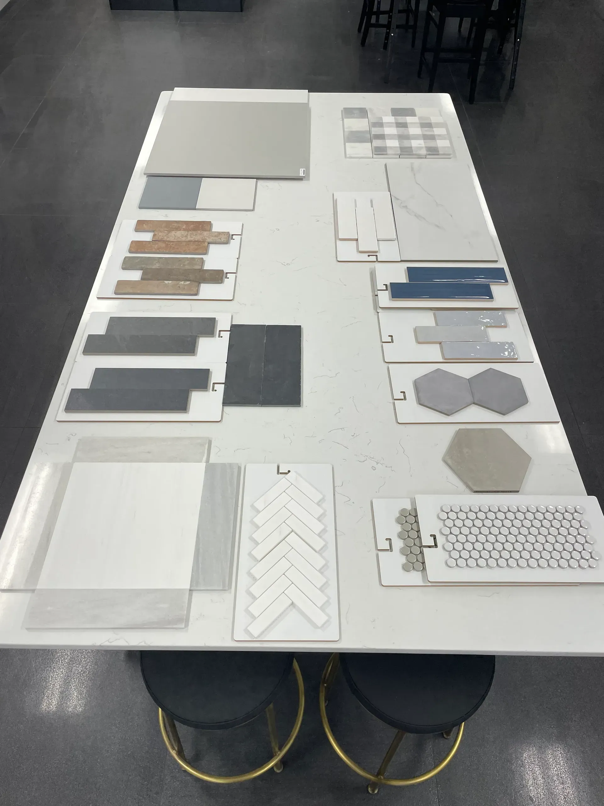 Table covered with white architectural sample boards and material swatches in a studio.
