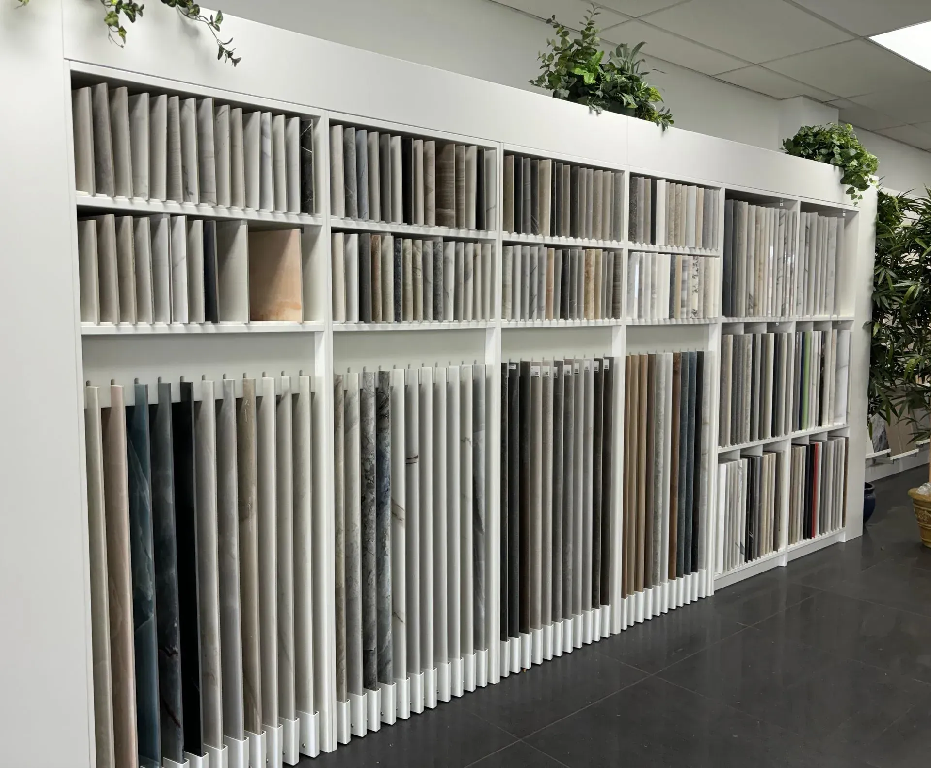Rows of fabric samples in white display shelves inside a showroom